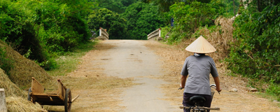 Fahrradfahrerin auf dem Land, Vietnam Reise
